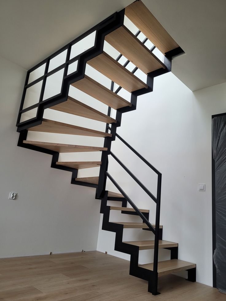 Stalowe schody dwubelkowe ze stalową balustradą oraz drewnianymi stopniami